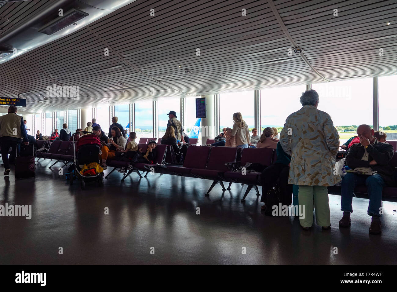Gente esperando para vuelos en la Terminal 3 del aeropuerto de Manchester, Manchester, Reino Unido Foto de stock