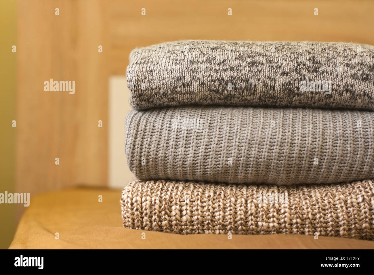 Un montón de suéteres tejidos en la cama de madera. Calentar ropa cómoda  Fotografía de stock - Alamy