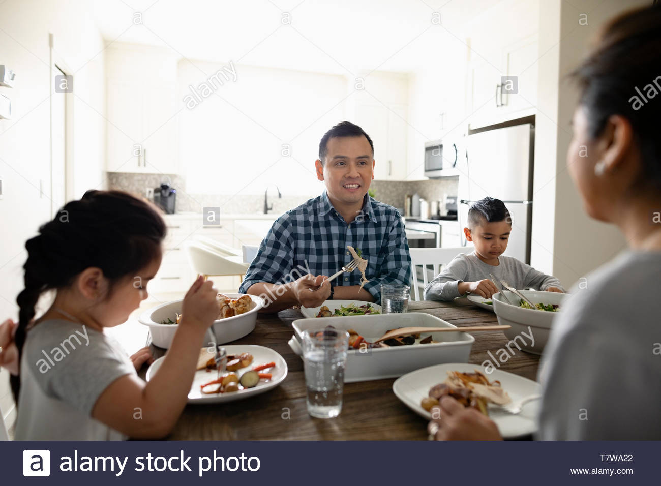 Familia disfrutando de la cena en la mesa de comedor Foto de stock