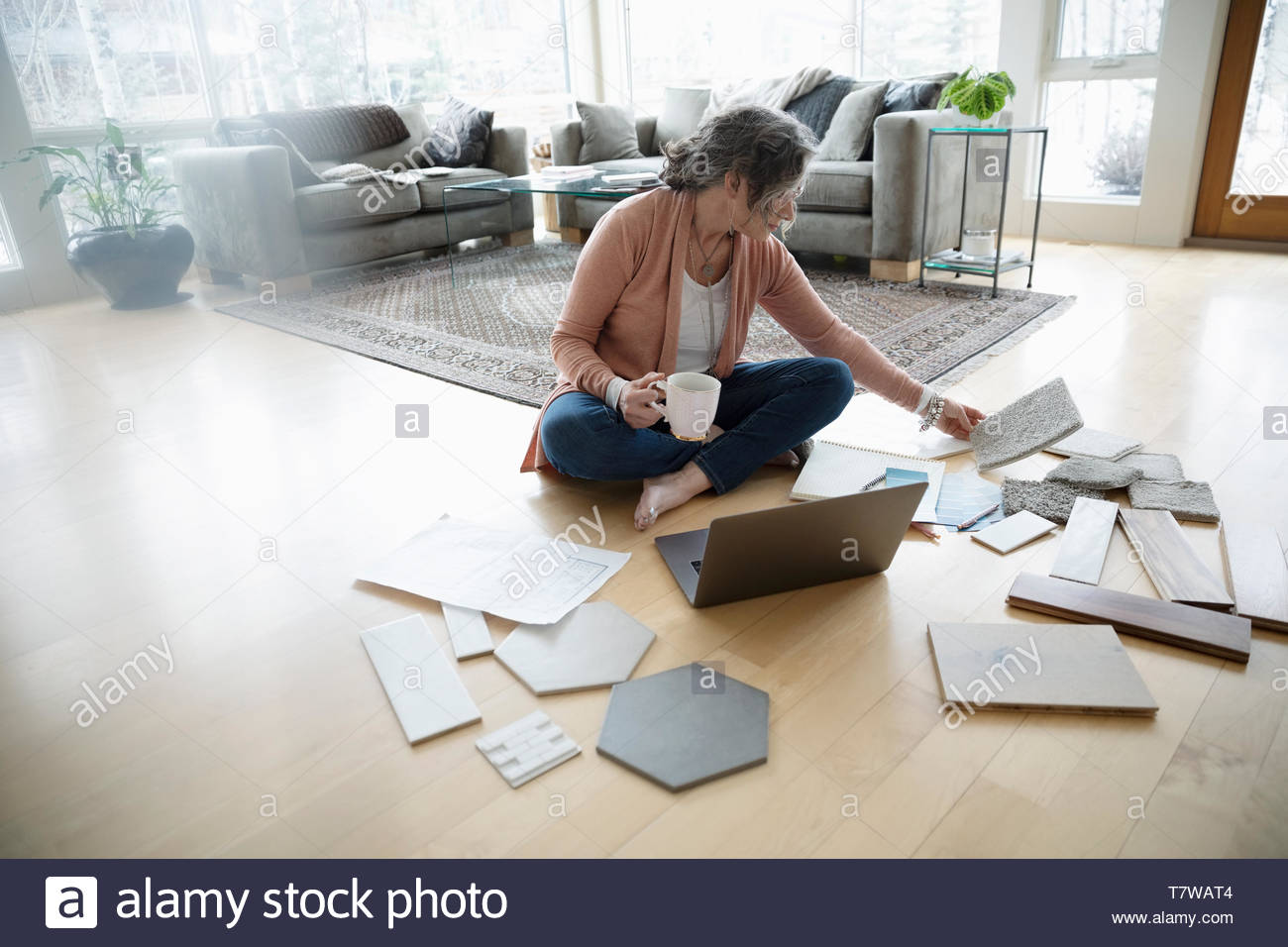 Mujer Senior redecorar, mirando las muestras en el piso Foto de stock