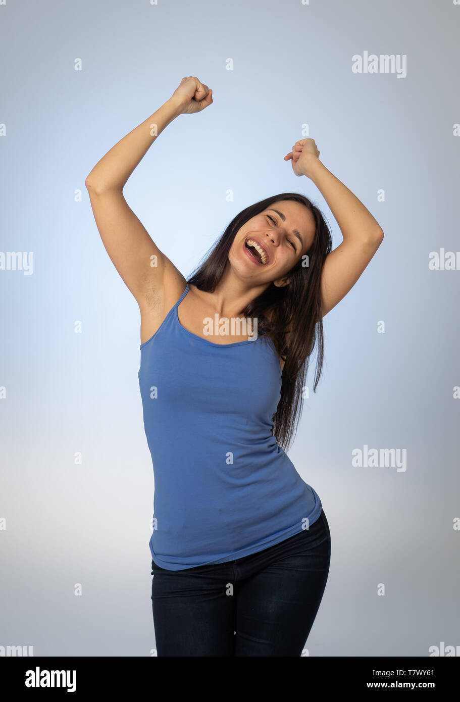 Retrato de joven mujer atractiva celebrando el éxito de la ganadora o se siente afortunado y gozosa celebración bailando y haciendo gestos con los brazos aislados Foto de stock