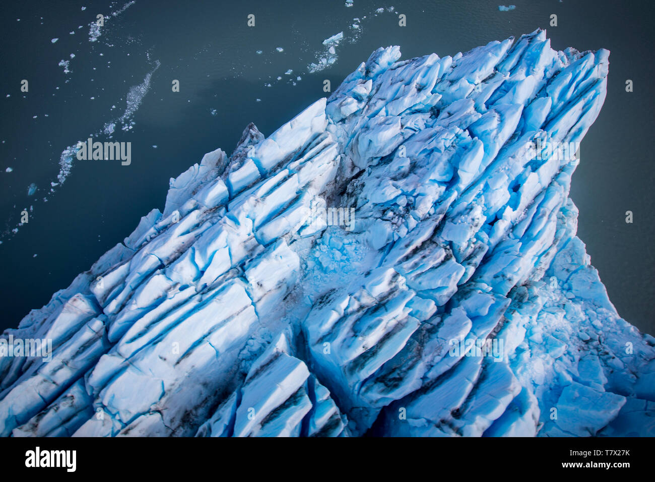 El Glaciar Knik en Alaska. La falta de cubierta de nieve exponer la precipitación de cenizas del volcán reducto cercano, reduciendo el efecto de albedo. Hay miles de los glaciares en Alaska, y al menos 616 de ellas se nombran. Juntos, ellos están perdiendo 75 mil millones de toneladas de hielo cada año debido a la fusión. Es probable que esa cifra aumente en los próximos años. En mayo del 2015 fue el más caluroso en 91 años. El color azul es Naturally Occuring, pero es mejorado por underexposing la imagen. Foto de stock