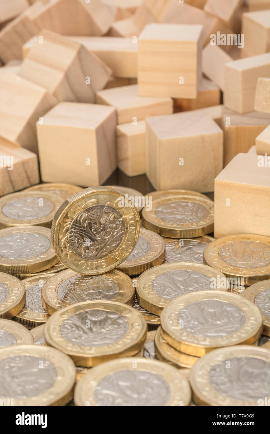 Nuevas monedas de libra + ladrillos y bloques de madera revolteados/tambaleados. Libra esterlina desplome, caída en £, libra venta-off el tipo de interés desplome, caída del mercado 2020 Foto de stock