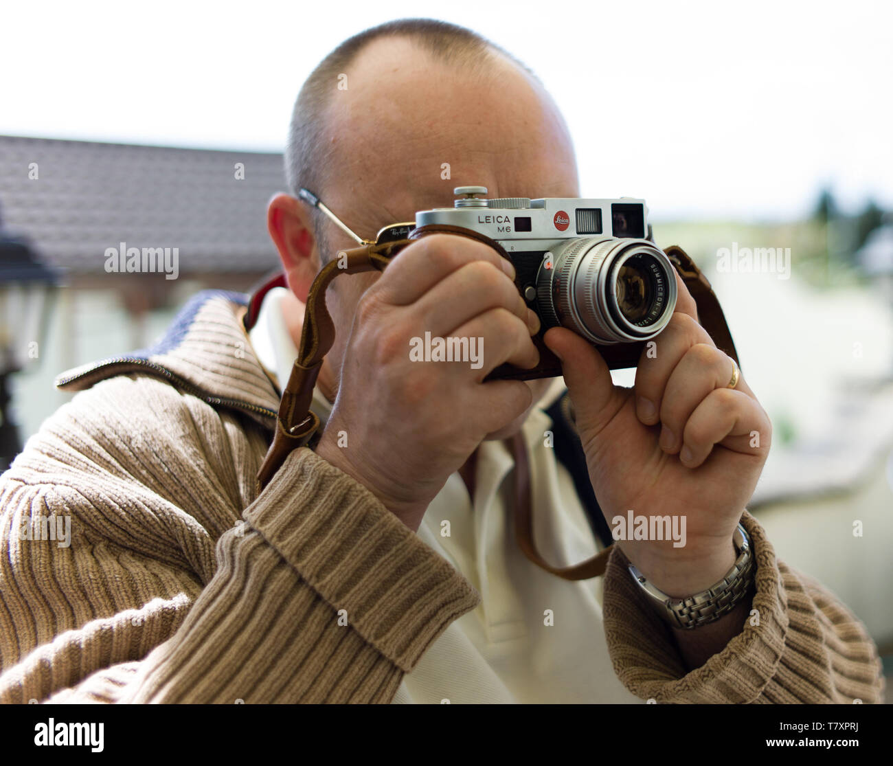 Hombre utilizando vintage Leica M6 equipado con una cámara de película de 50mm Zeiss sonnar® Foto de stock