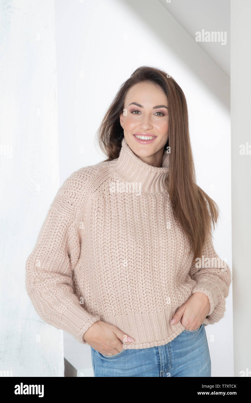 Mujer sonriente en un suéter beige Fotografía de stock - Alamy