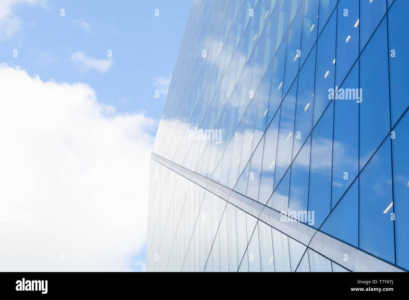 La arquitectura comercial moderno abstracto, paredes de metal y cristal brillante bajo el azul cielo nublado Foto de stock