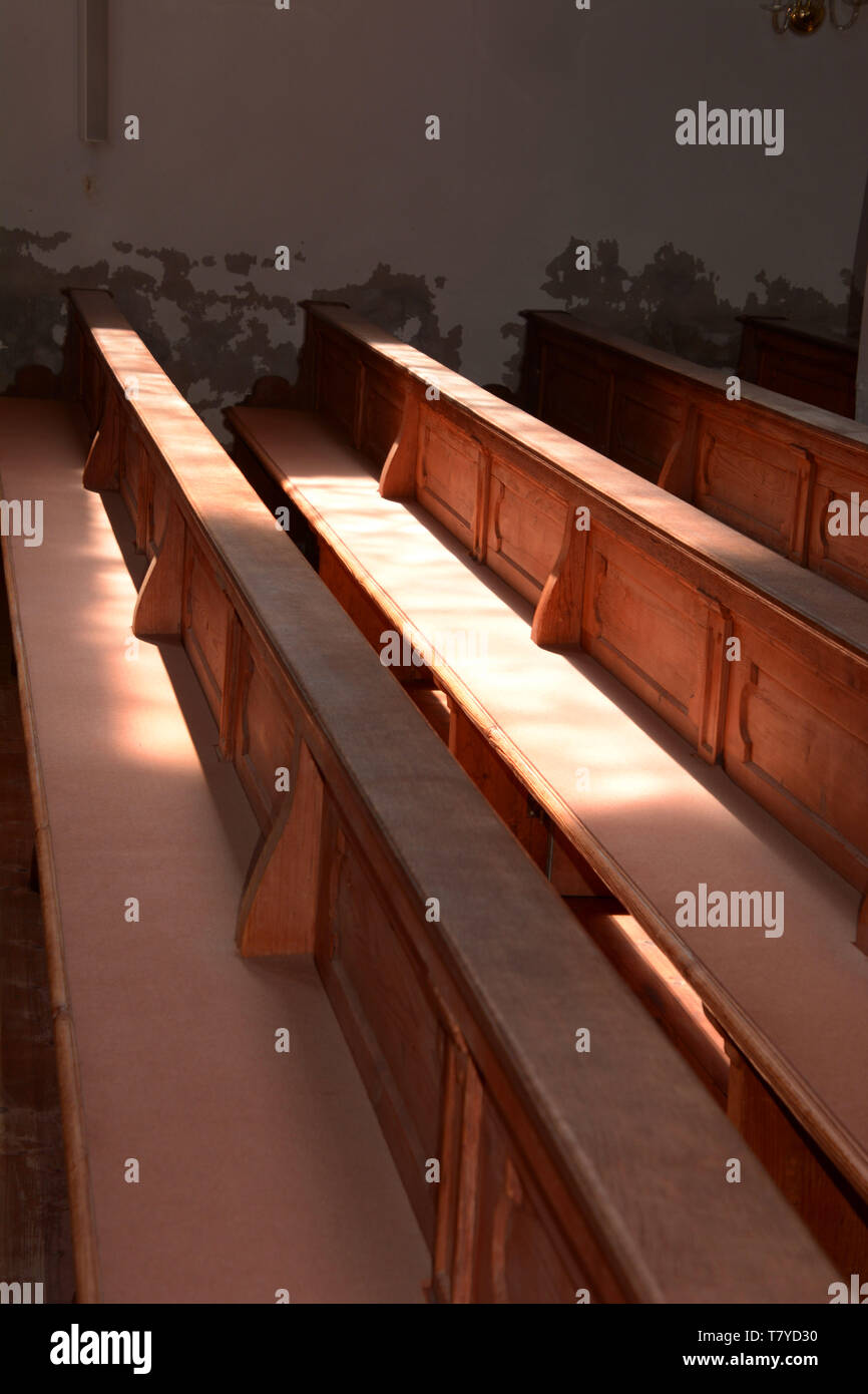 Vista del interior de las paredes de la iglesia antigua se desmenuzan y bancas de madera vacías sin gente, las filas de bancos de iglesia de madera iluminados por el sol a Vista del interior de las paredes de la iglesia antigua se desmenuzan y bancas de madera vacías sin gente, las filas de bancos de iglesia de madera iluminados por el sol a