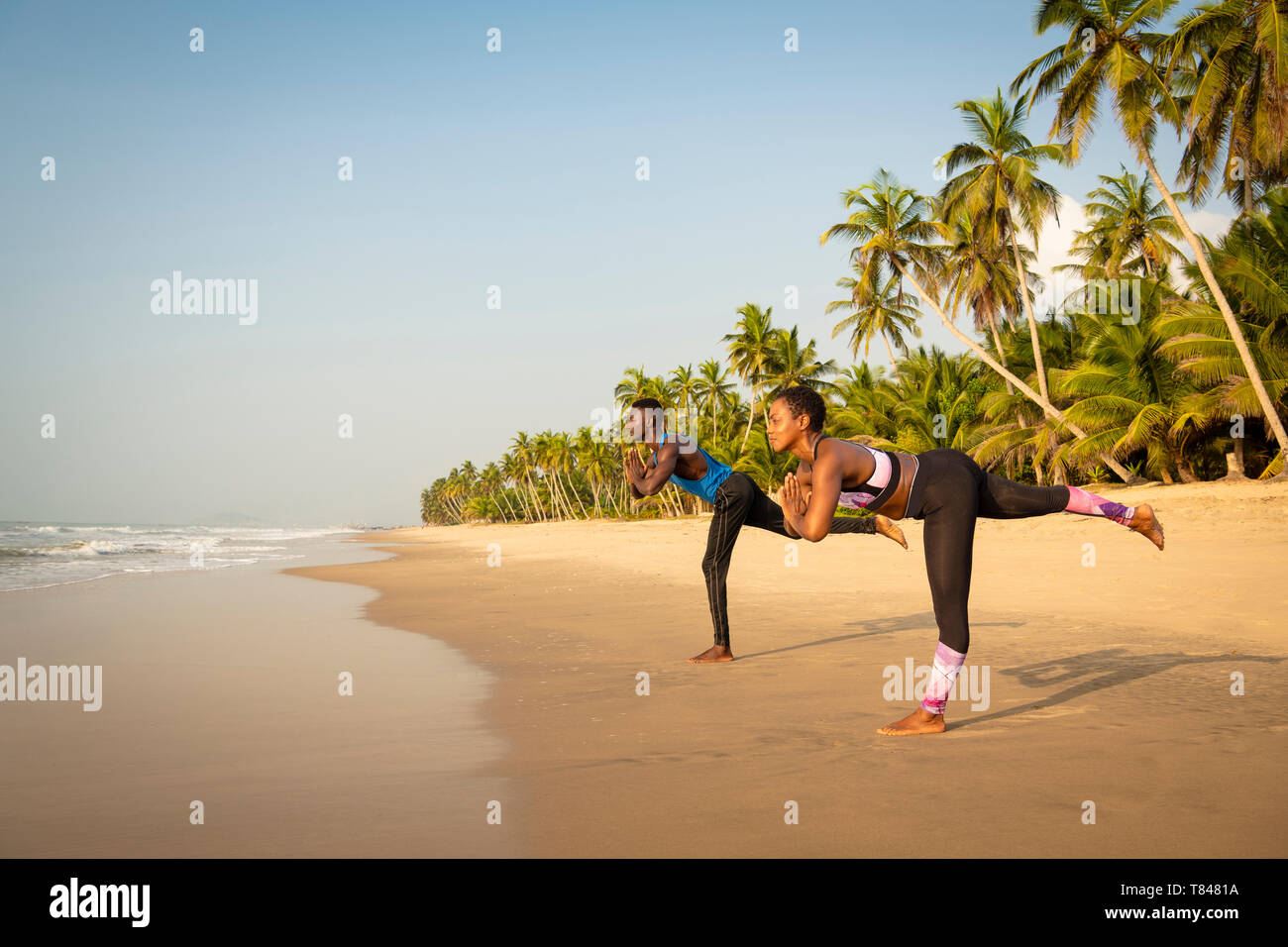 Pareja practicando yoga en la playa Foto de stock