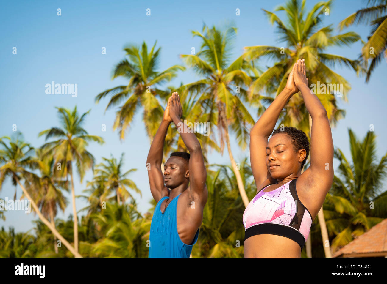 Pareja practicando yoga en la playa Foto de stock