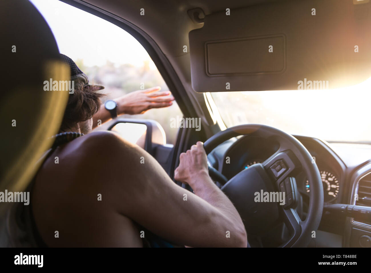 El hombre coche el blindaje de los ojos de la luz solar, vista sobre el hombro Foto de stock