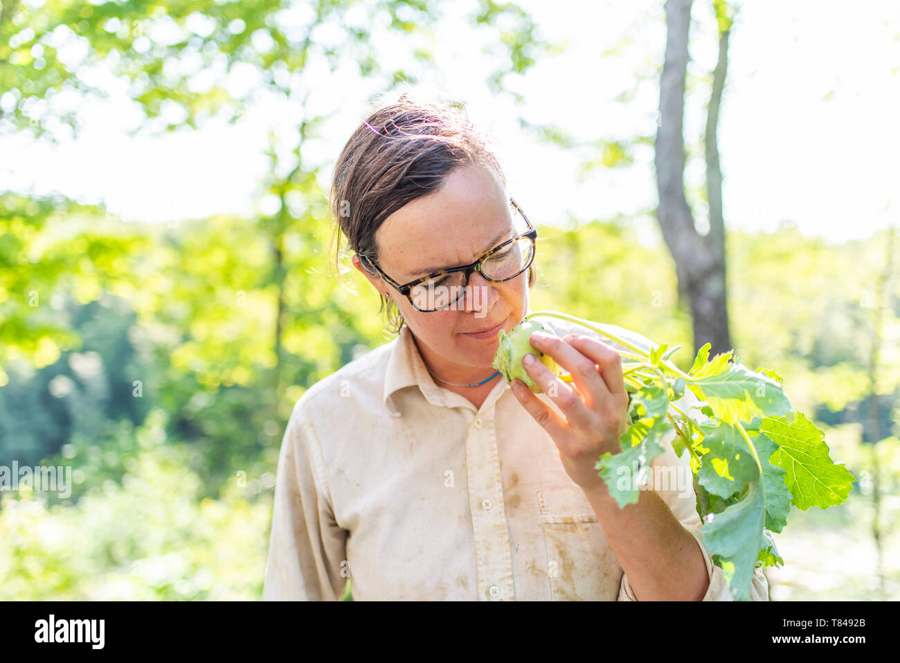 Hembra madura jardinero busca verdes en el jardín Foto de stock