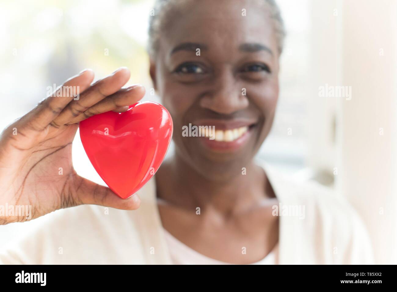 Mujer sosteniendo con forma de corazón Foto de stock