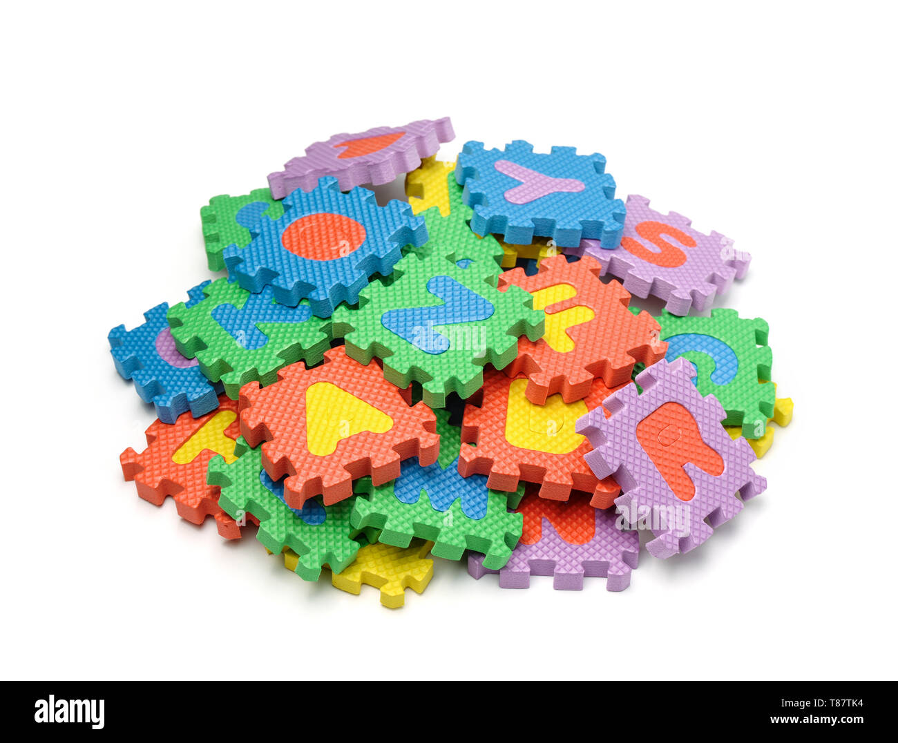 Montón de coloridas piezas de puzzle alfabeto espuma aislado en blanco Foto de stock