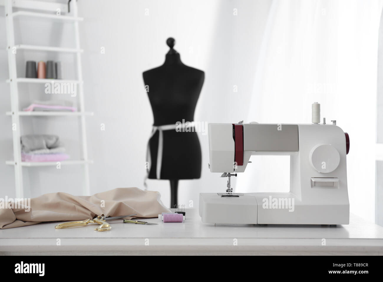 Máquina de coser moderna con telas y sastrería de suministros en el cuadro  en el taller Fotografía de stock - Alamy