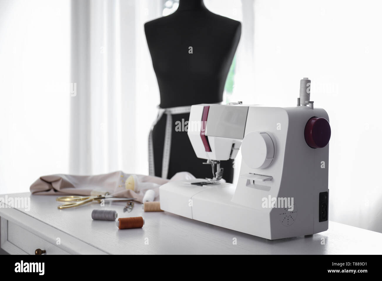 Máquina de coser moderna con telas y sastrería de suministros en el cuadro  en el taller Fotografía de stock - Alamy