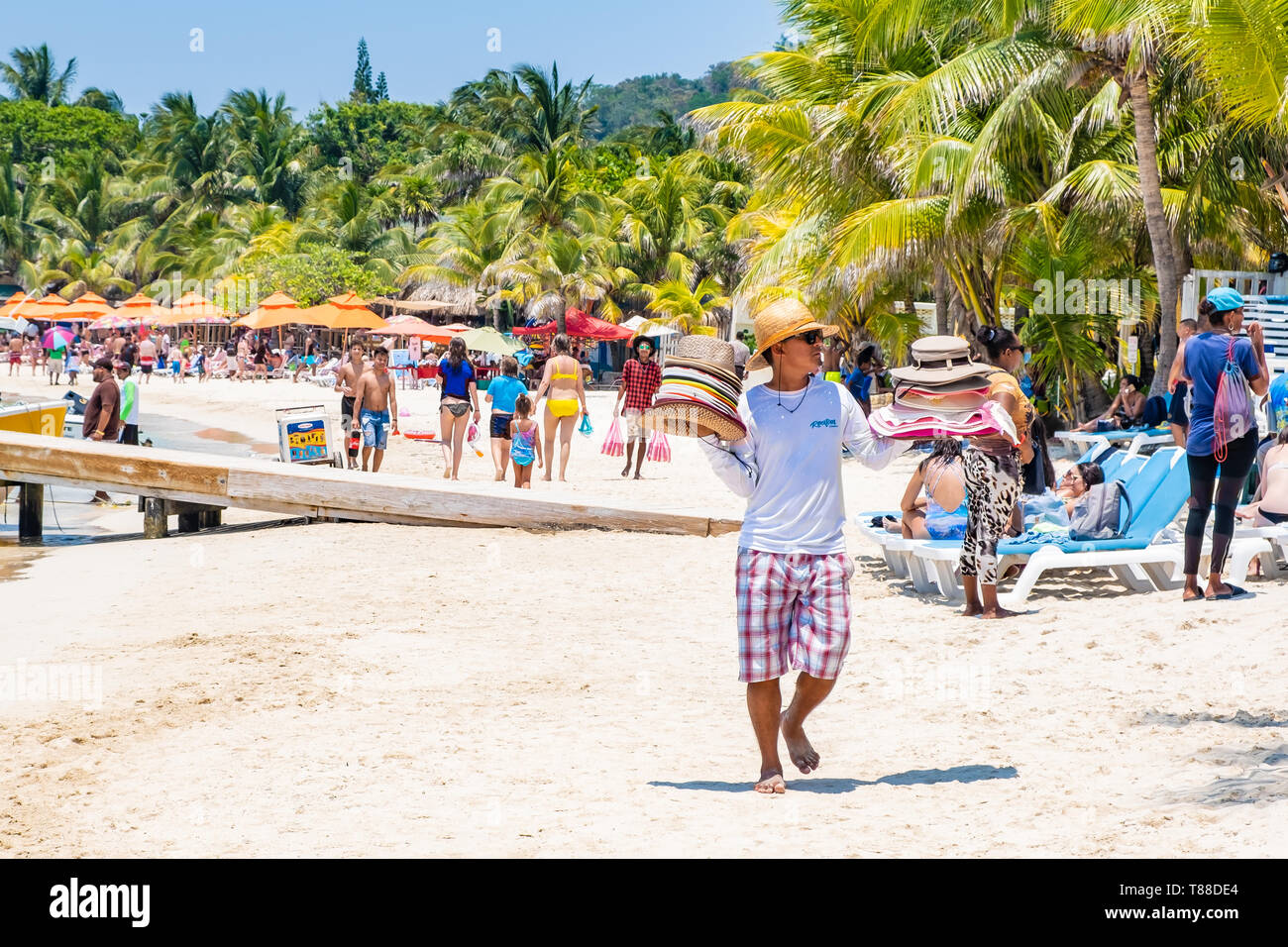 Locales varones hasts vendedor vende a los turistas en la playa de West Bay, Roatán, Honduras. Foto de stock