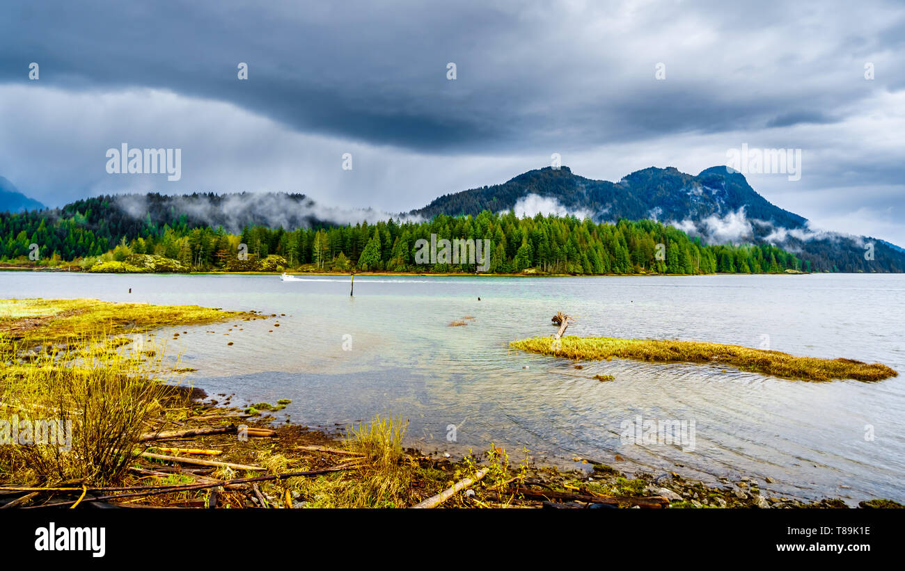 Oscuro cielo nublado por Pitt Lake y merodeando por las montañas de la Cordillera de la costa en el Valle del Fraser de British Columbia, Canadá Foto de stock