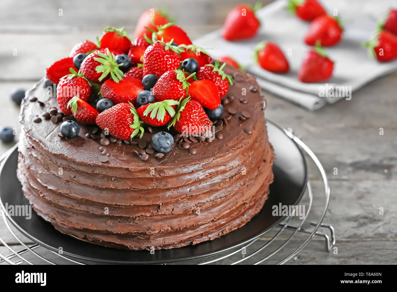 Deliciosa torta de chocolate, decorado con fresas y arándanos sobre mesa de  madera Fotografía de stock - Alamy