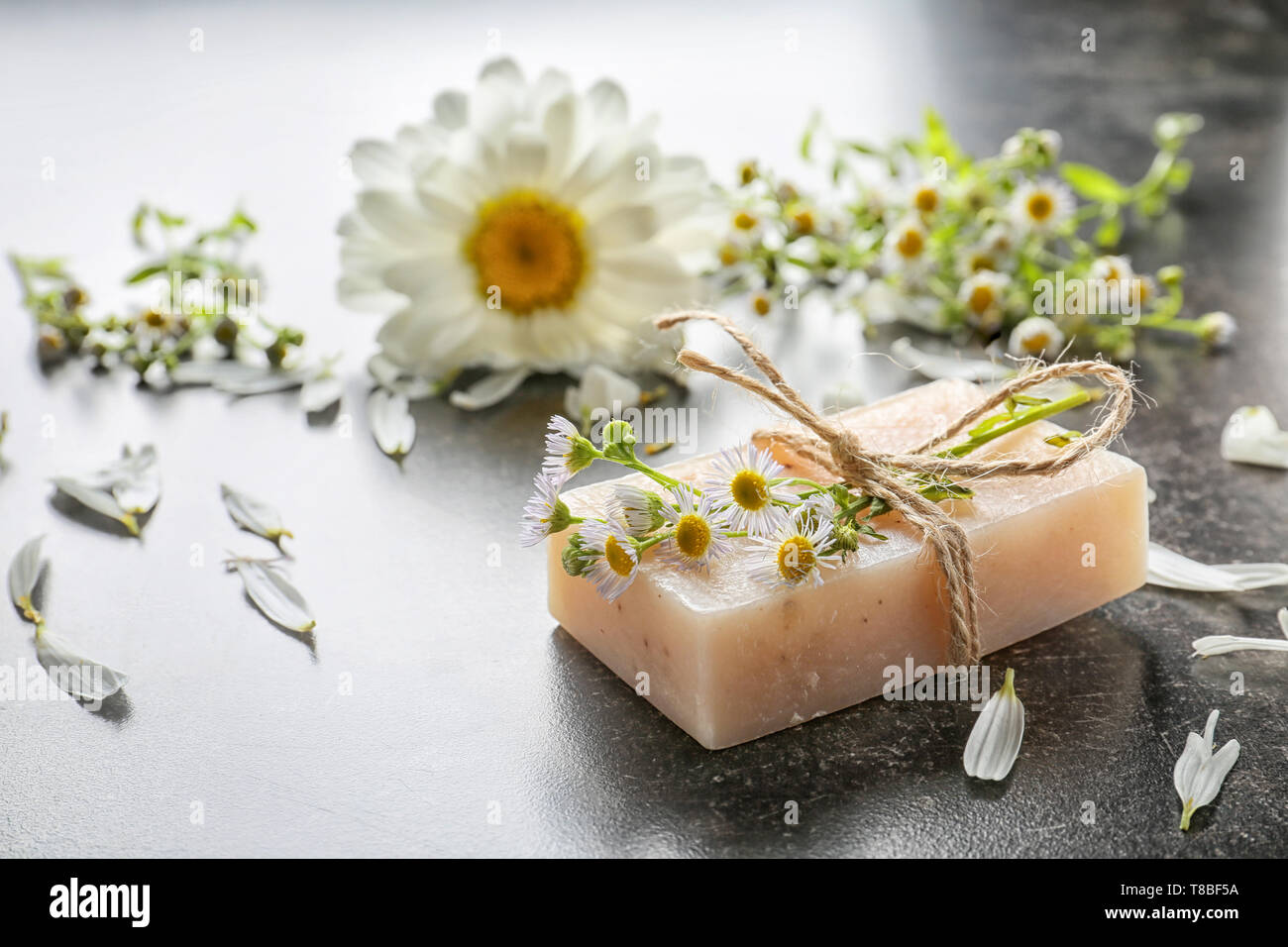 Jabón casero natural con flores de manzanilla en la mesa