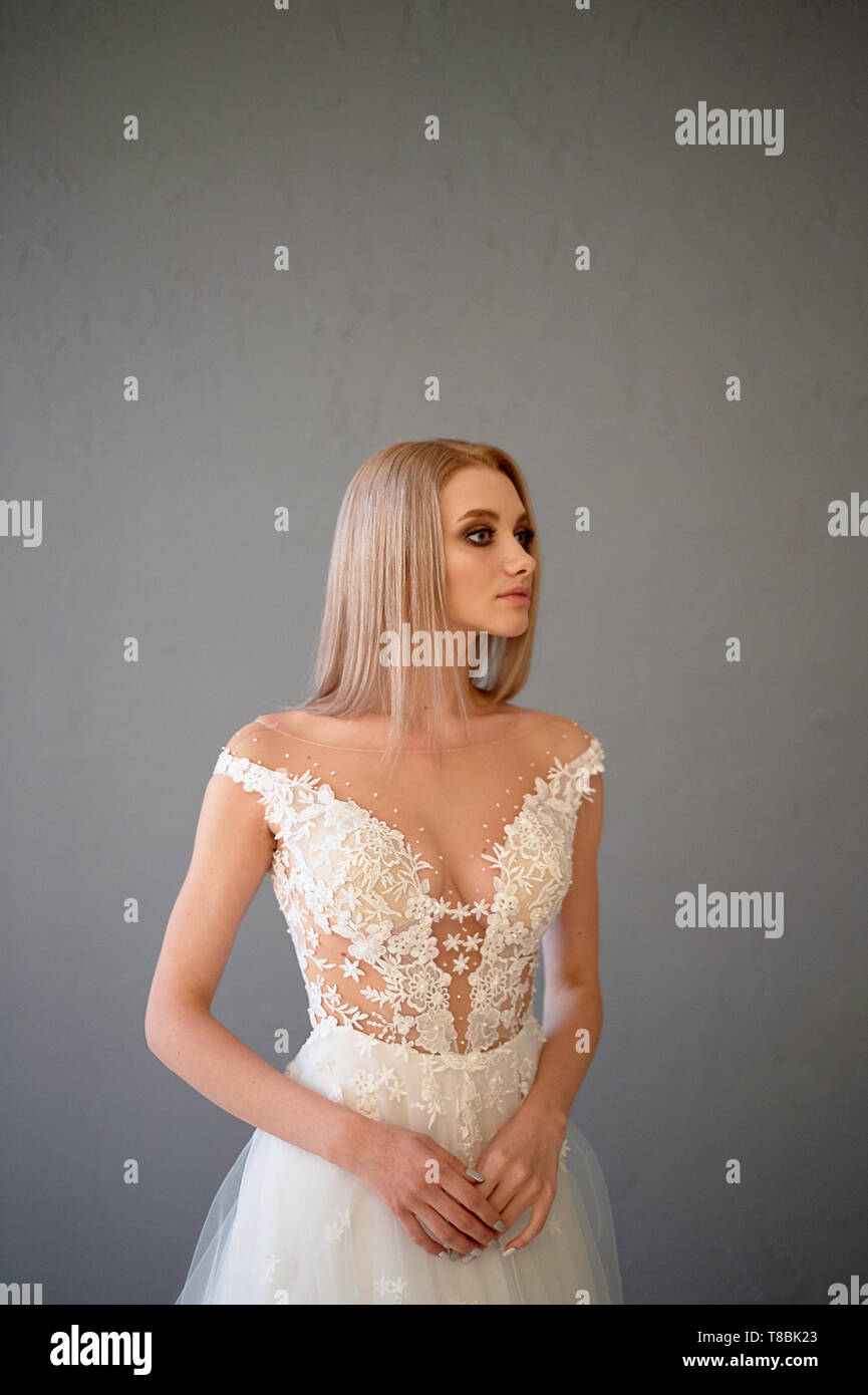 La novia en un blanco vestido encaje bordado con canesú, interiores en  estilo loft. Long,fluyendo, cenizas de color del cabello Fotografía de  stock - Alamy