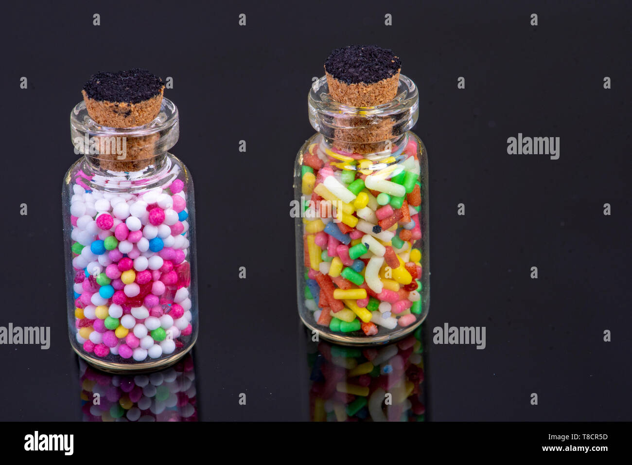 Botellas de vidrio con buten dulces llenos en cristal negro con duplicación  con corcho de pie Fotografía de stock - Alamy