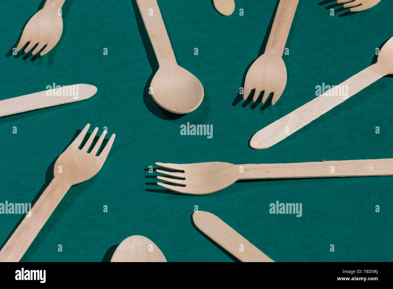 Concepto de protección de tierra. madera cucharas y tenedores biodegradables  en el fondo verde Fotografía de stock - Alamy