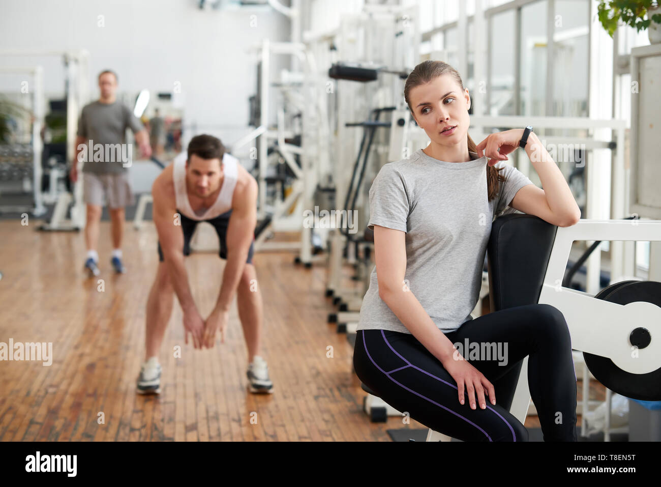 Agotado colocar mujer relajante después de gimnasio de ejercicios. Bonita  mujer reflexiva descansa después del entrenamiento físico con el joven  apuesto hombre trabajando en la espalda Fotografía de stock - Alamy