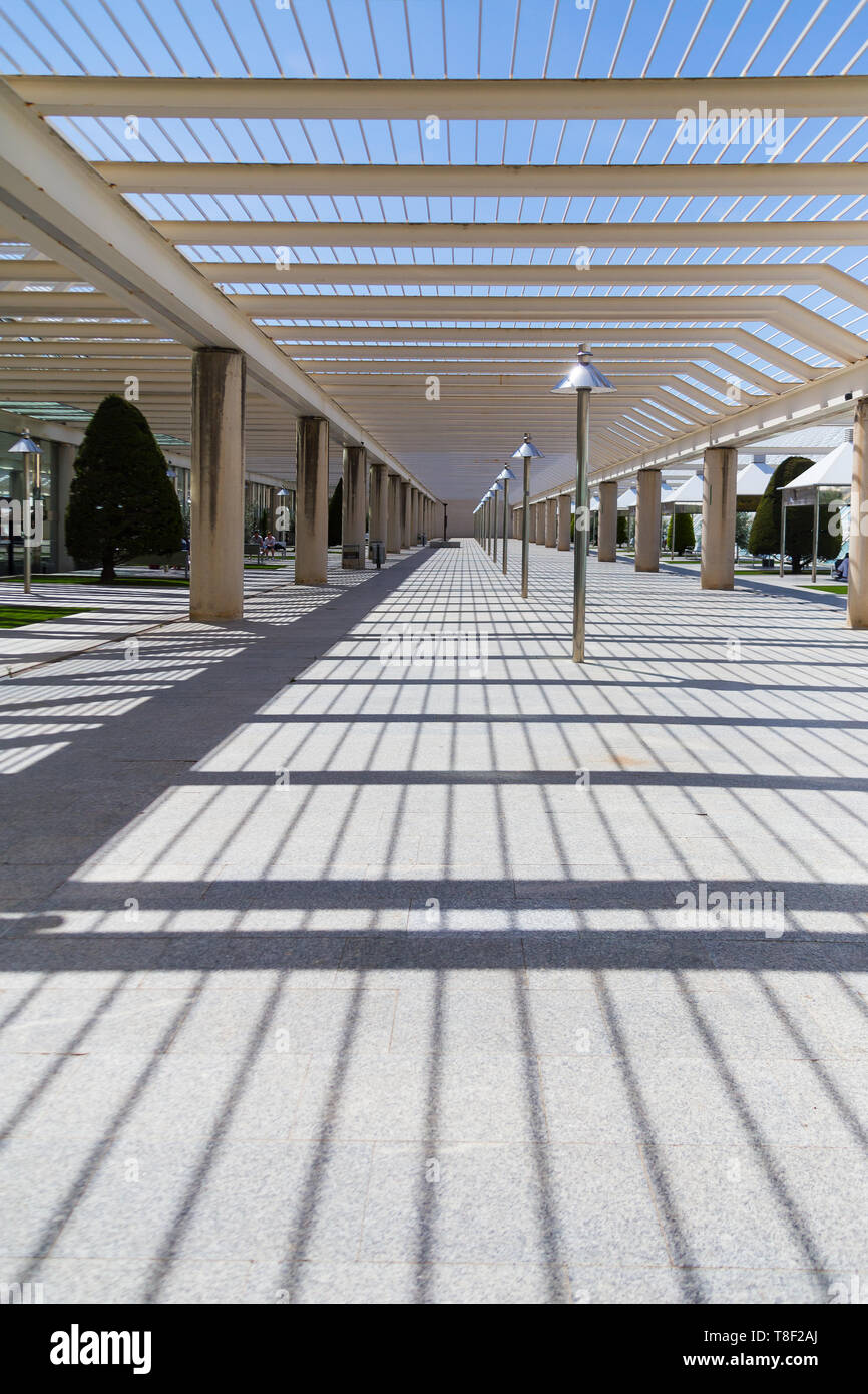 El patio en el aeropuerto, un lugar para fumar y esperar para su embarque en el exterior. Arquitectura moderna con columnas y vigas de metal. Decorado con coníferas, pequeños jardines y mirador. Foto de stock