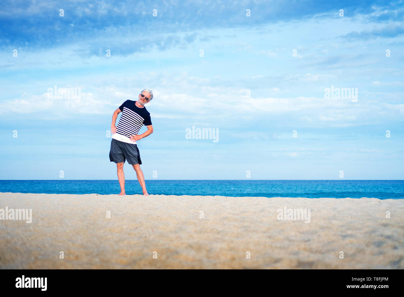 El hombre superior ejerce sobre la playa, el estilo de vida saludable Foto de stock
