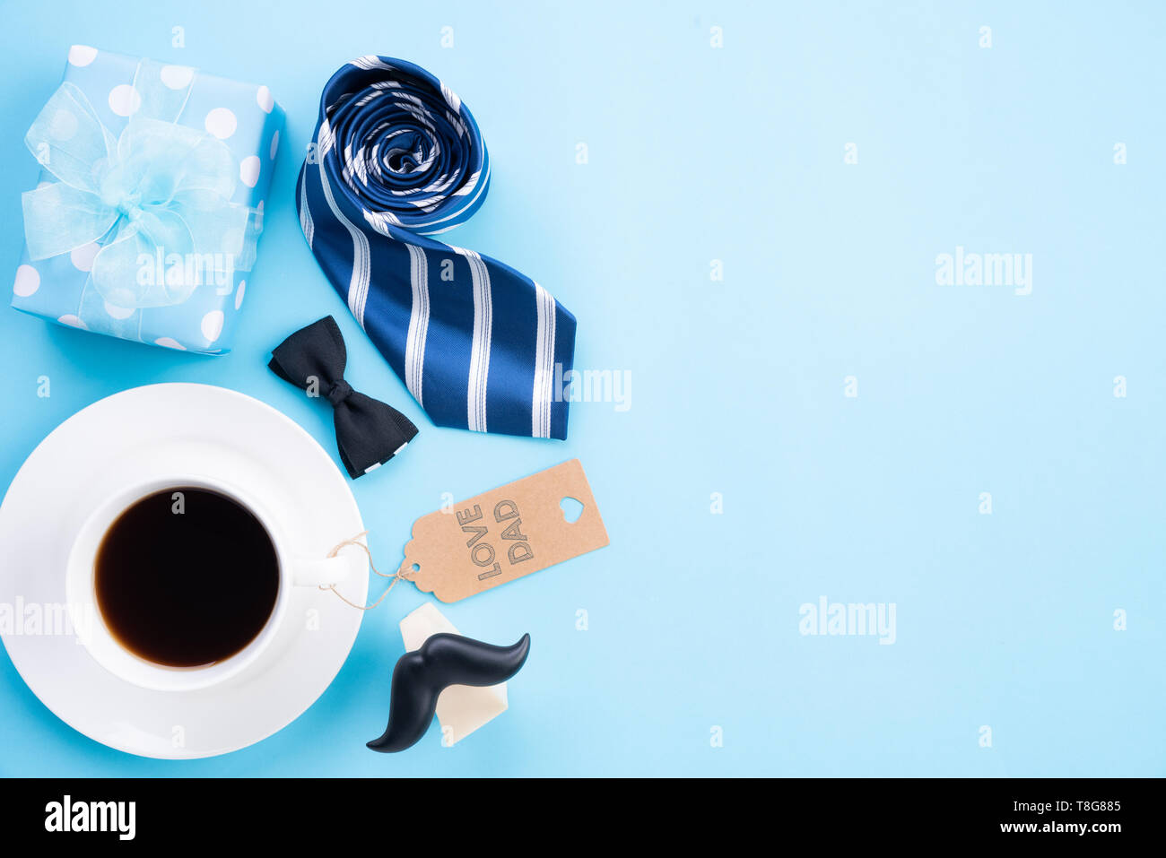Feliz Día del padre concepto. Vista superior de la corbata azul, preciosa  caja de regalo, taza de café, la etiqueta de papel con amor papá texto en  azul brillante de fondo pastel
