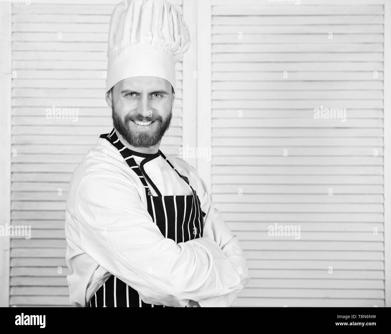 Hombre con delantal y sombrero de chef cocinando comida en la
