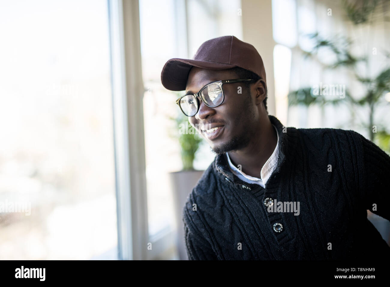 Retrato de pensativo empresario africano-americanos de pie cerca de la ventana y pensar sobre la decisión, soñando con éxito, ponderando nuevo inicio. Handsom Foto de stock
