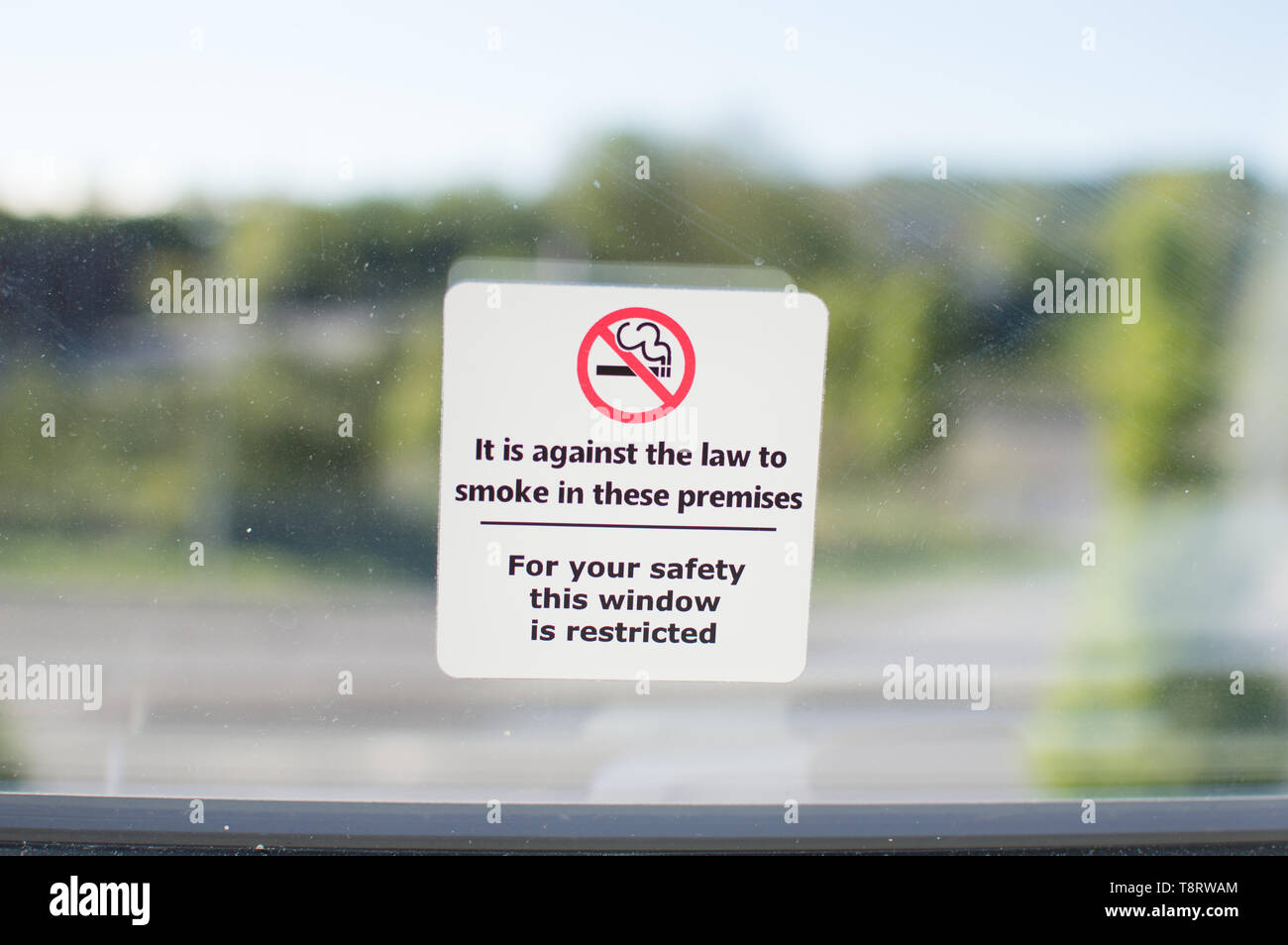 Un signo de no fumar y restricción de la ventana información sobre una ventana de vidrio en una habitación de hotel Foto de stock