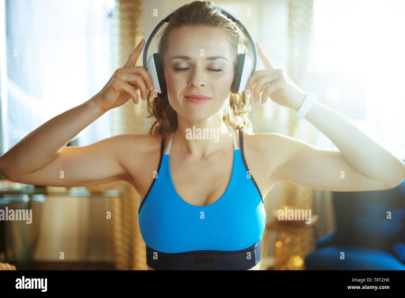 Mujeres asiáticas sanas escuchando música con auriculares mientras hacen  ejercicio en el gimnasio