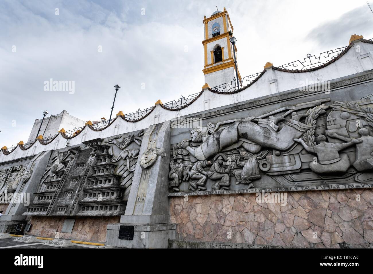 La Iglesia de Nuestra Señora de la Asunción picos desde atrás de la enorme escultura: Evolución de la cultura totonaco por Teodoro Cano García, en la Plaza Central de Israel Tellez Park La Iglesia de Nuestra Señora de la Asunción picos desde atrás de la enorme escultura: Evolución de la cultura totonaco por Teodoro Cano García, en la Plaza Central de Israel Tellez Park