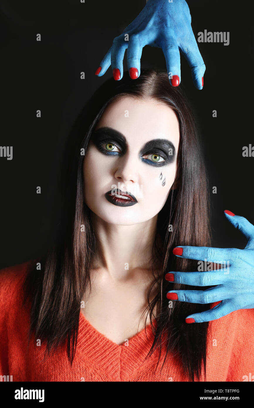 Manos de monster tocar mujer joven con maquillaje de Halloween sobre fondo  oscuro Fotografía de stock - Alamy