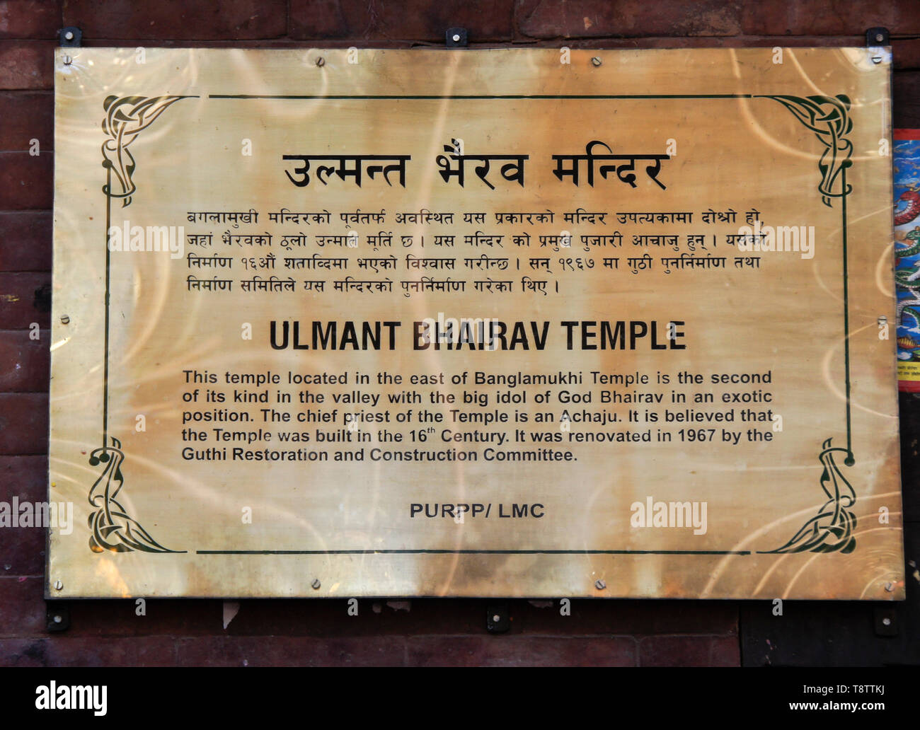 Bilingües (inglés y nepalí) cartel informativo sobre Ulmant Bhairav templo hindú, Patan, el Valle de Katmandú, Nepal Foto de stock