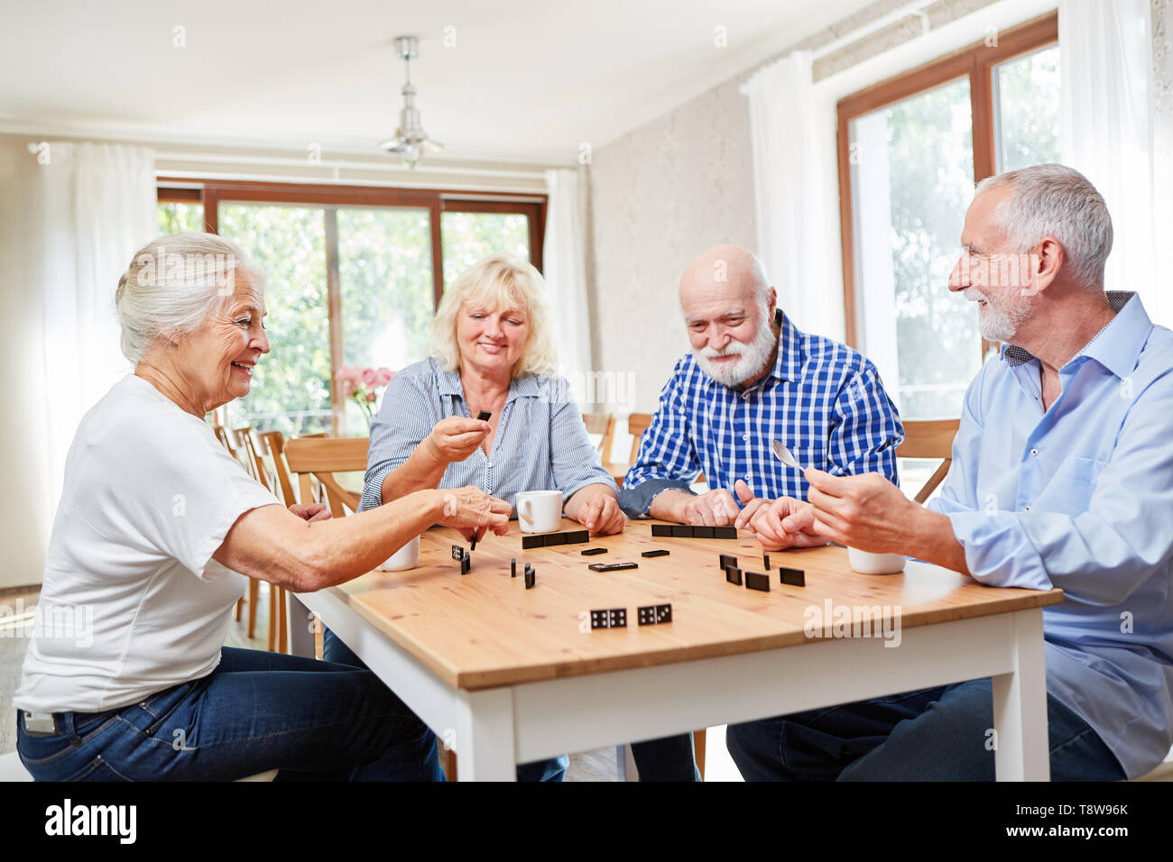 Los ancianos como amigos a jugar dominó juntos en una casa de retiro o  jubilación home Fotografía de stock - Alamy