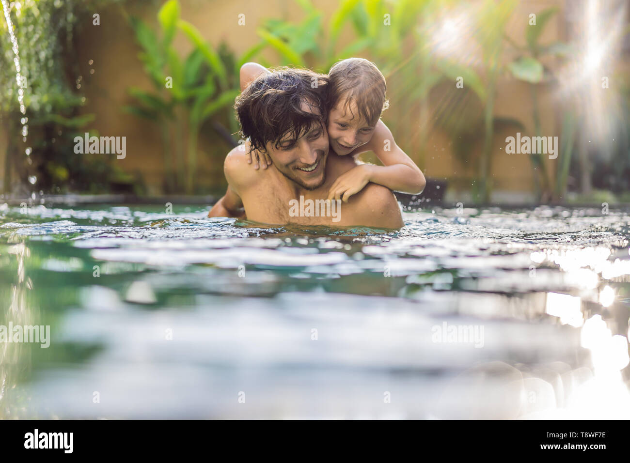 Padre e hijo se divierten en la piscina Foto de stock