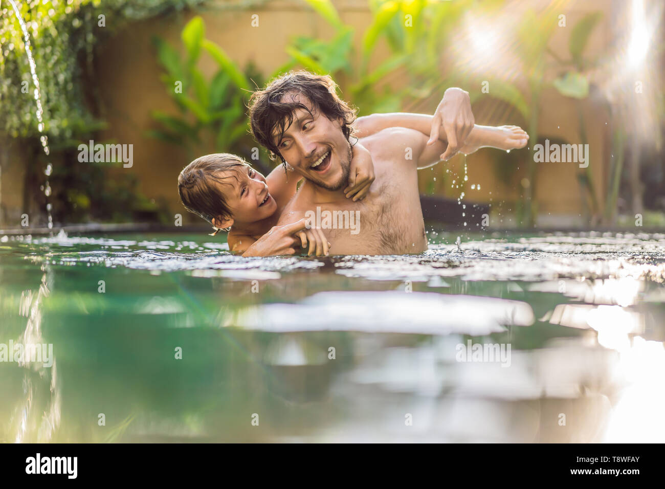 Padre e hijo se divierten en la piscina Foto de stock