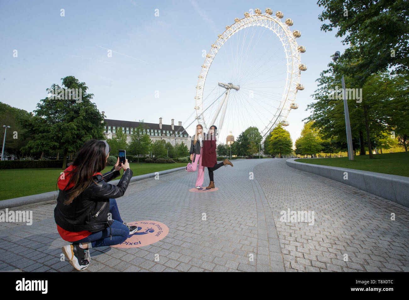 Los turistas tienen su foto tomada en el London Eye en Londres, como Google ha trazado exactamente donde encaje la nación favorita de fondos fotográficos para celebrar el lanzamiento de pixel 3a. Foto de stock