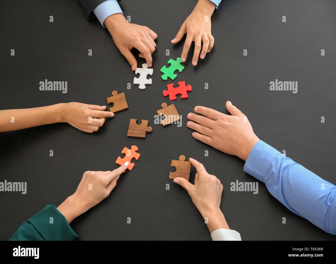 Equipo empresarial armar rompecabezas de tabla oscura Fotografía de stock -  Alamy