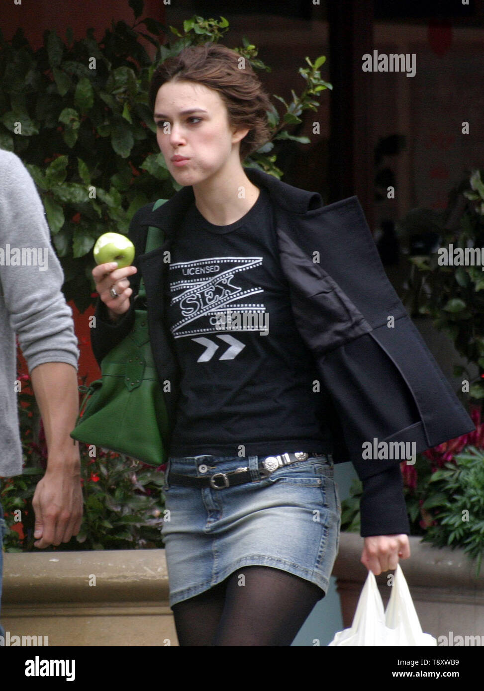Kiera Knightley en West London comiendo una manzana en el go! Llevaba una falda corta de Jean y pelo corto foto por Tony Henshaw Foto de stock