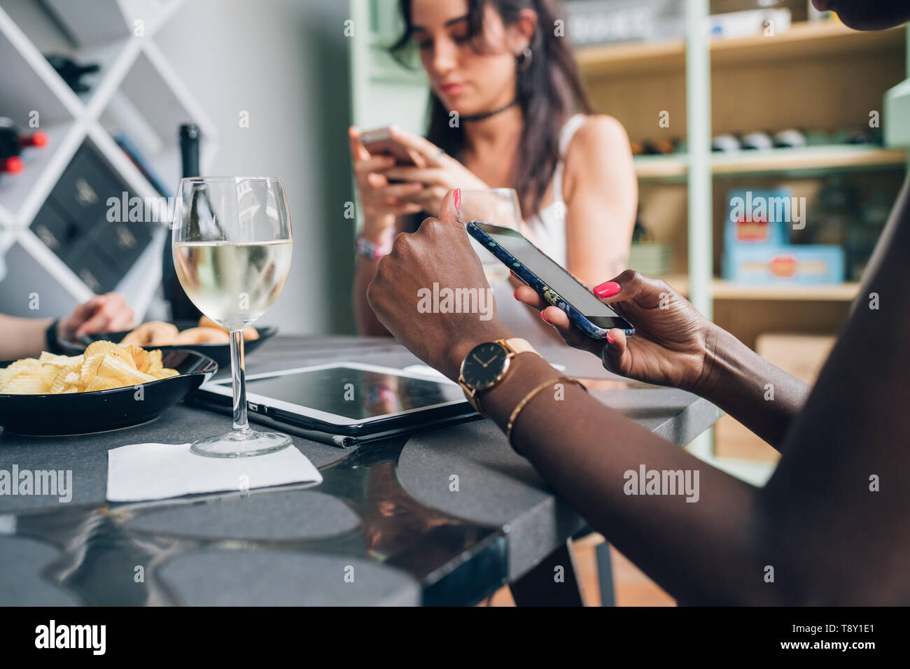 Las niñas multiétnica bebiendo y charlando con el smartphone - conexión; juventud; tecnología Foto de stock