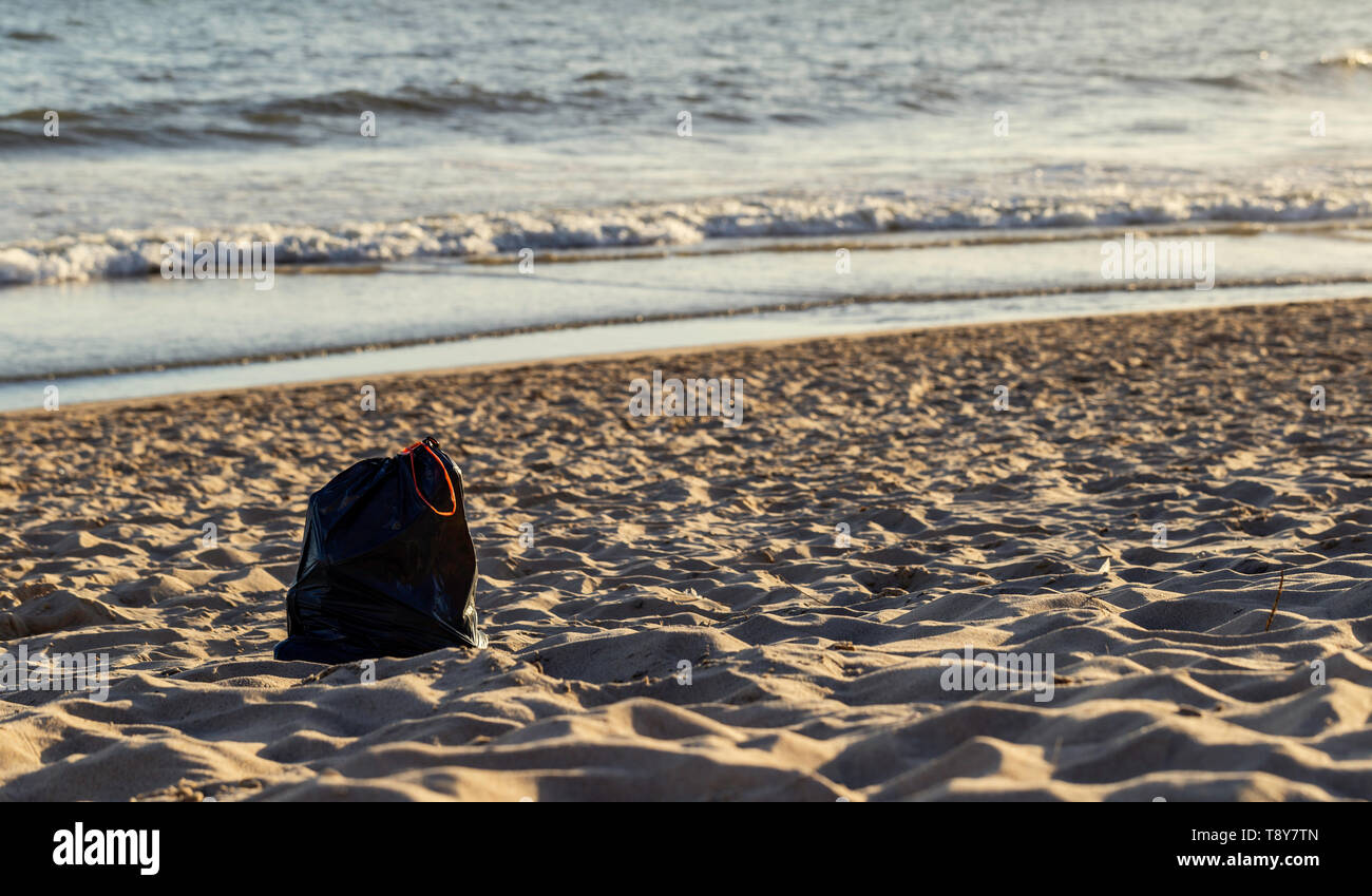 Utiliza bolsas de plástico basura y desperdicios en la arena de la playa para el tema ambiental concepto. Problemas de la catástrofe ecológica. Sandy soleada orilla Foto de stock