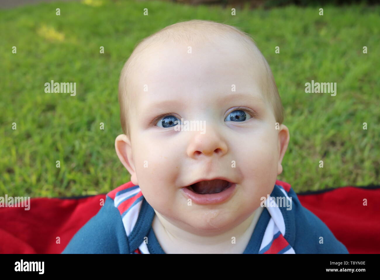 Retrato de un bebé feliz con grandes ojos azules, en patriótico outfit Foto de stock