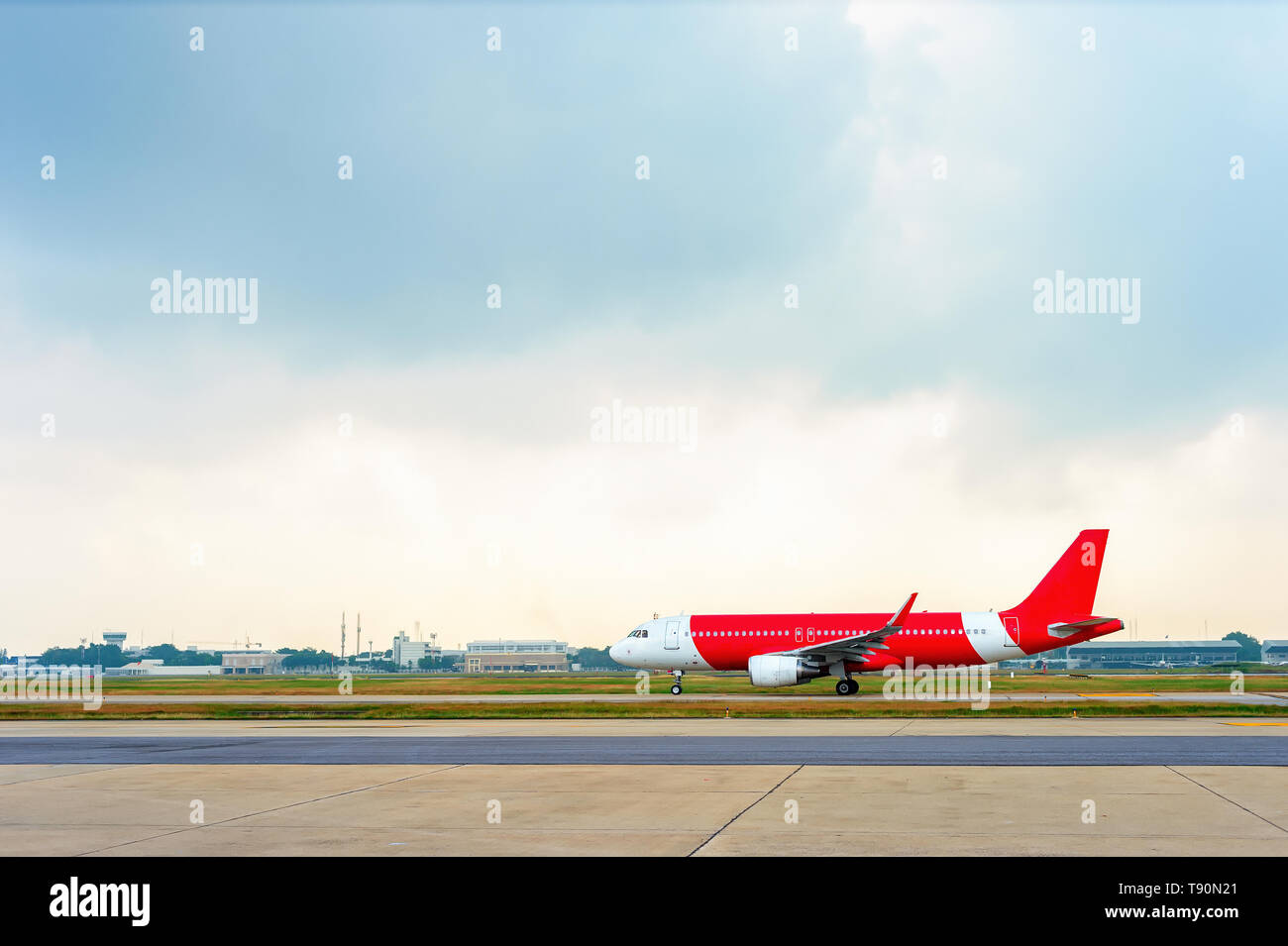 En la pista de aterrizaje del avión rojo, nublado horizonte con airport en segundo plano. Foto de stock