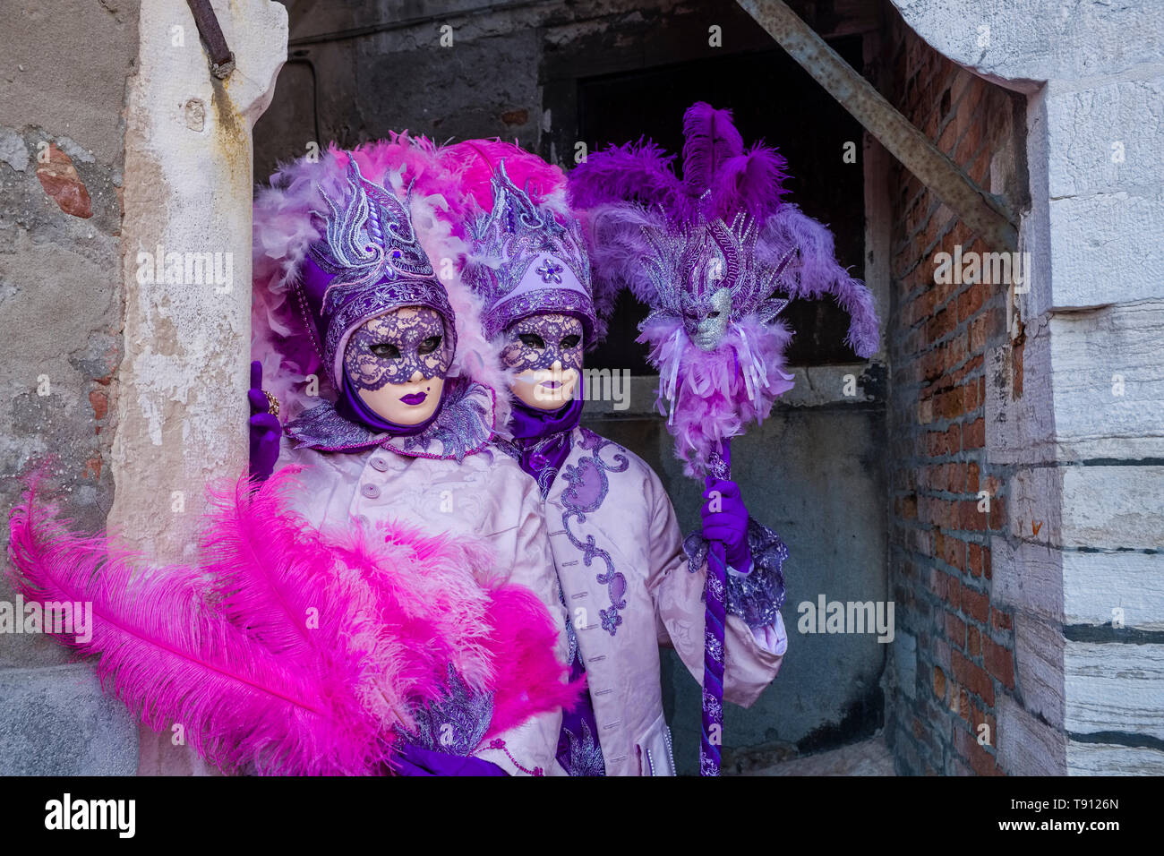 Dos personas enmascaradas feminin en hermosos disfraces creativos, posando  en una afligida portada, celebrando el carnaval veneciano Fotografía de  stock - Alamy