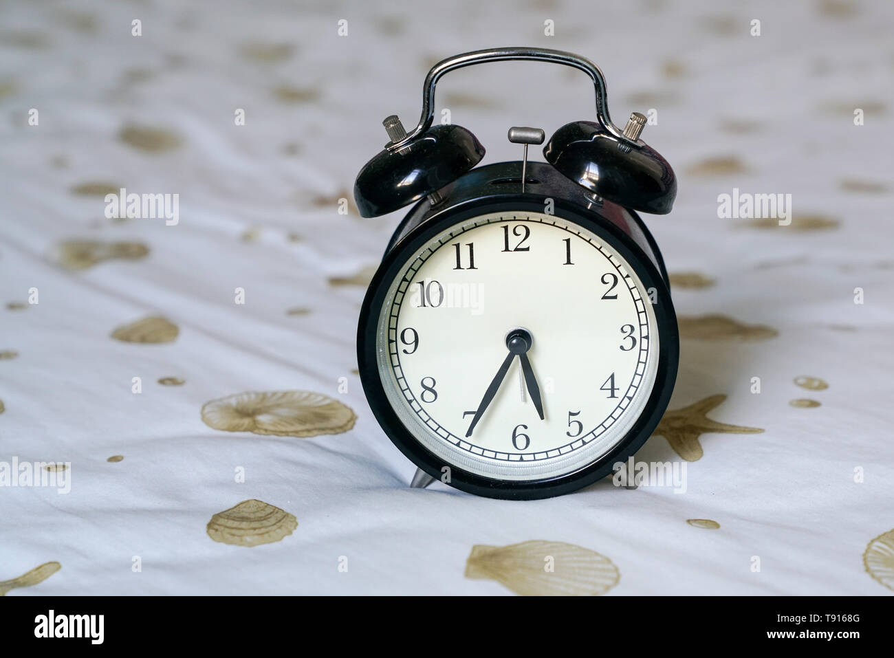 Reloj Despertador retro negro en la parte superior de la cama Fotografía de  stock - Alamy