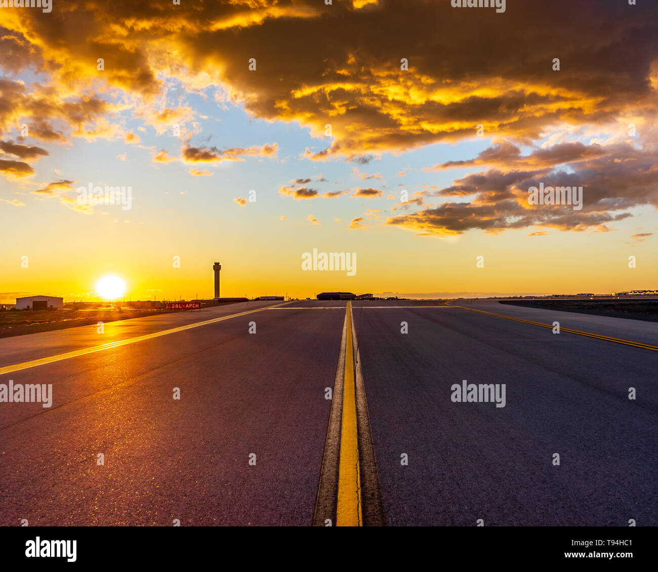 El sol se pone con la torre de control del tráfico aéreo en el fondo Foto de stock